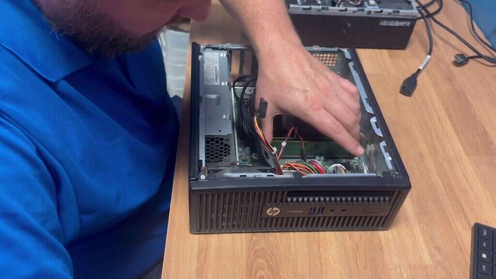 Buffalo IT Services technician performing hardware repair inside an HP ProDesk desktop