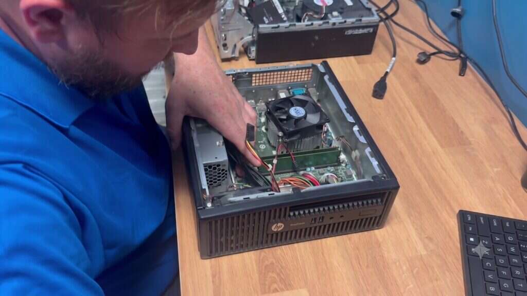 Buffalo IT Services technician installing memory and inspecting the CPU cooler in a desktop PC
